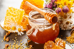 A bowl of honey with honey stick