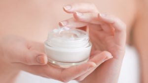 women is holding face cream for women 