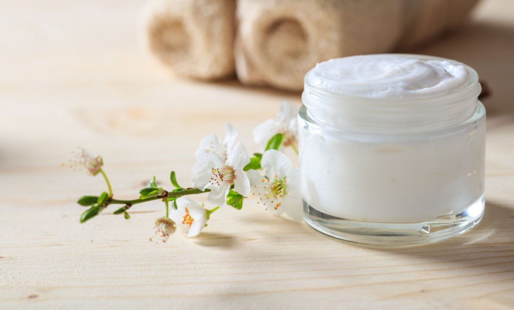 Men face cream with flowers on table