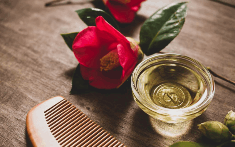 Oil for hair growth bowl, comb and flower on table