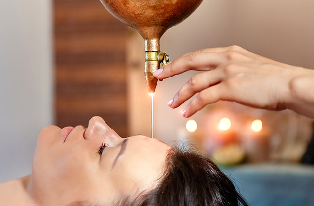 lady is getting warm oil massage on her head